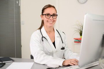 portrait of a beautiful woman female doctor in medical practice office working on computer