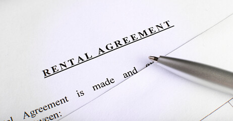 rental agreement form on desktop with pen in business office showing real estate concept