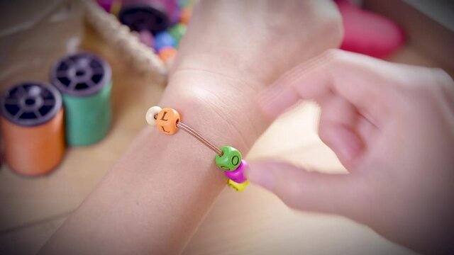 String a bracelet Wooden letter beads of LOVE word, Close up woman hand string with a colourful LOVE Wooden letter beads, mood and tone VALENTINE concept.