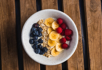 Healthy bowl of fruits in a wood background