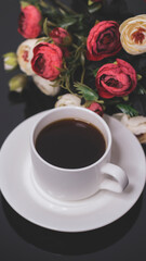 Cup of coffee and flowers. An invitation to a romantic evening. Hearts bokeh, red light effect. Vintage background for postcards.