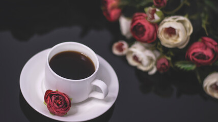 Obraz na płótnie Canvas Cup of coffee and flowers. An invitation to a romantic evening. Hearts bokeh, red light effect. Vintage background for postcards.