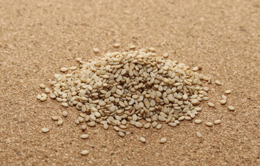 Fototapeta na wymiar Integral sesame seeds pile on cork mat, plug background and texture