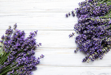 Fresh flowers of lavender bouquet, top view on white wooden background