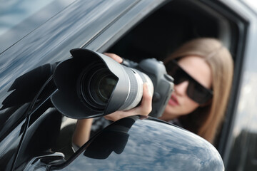 Private detective with camera spying from car, focus on lens