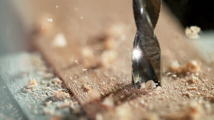 Detail of drill making hole into plywood