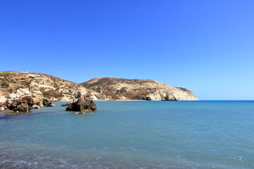 Aphrodite Beach with Stone Rocks in Aphrodite bay of Mediterranean sea water, blue sky in sunny day background, Petra tu Romiou, Cyprus