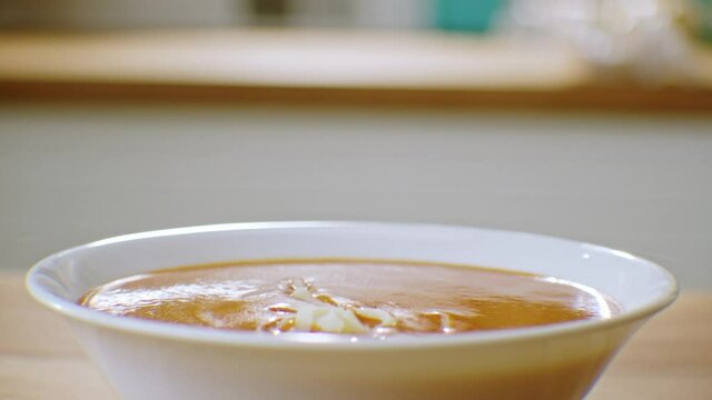 Traditional Turkish soup. Tomato soup.Grated cheddar cheese is thrown into the hot soup. Slow motion.
