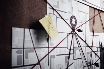 Detective board with map, sticker and red threads, closeup