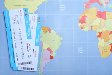 Tickets on world map, flat lay. Travel agency concept