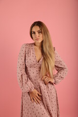 Young woman in dress on pink background