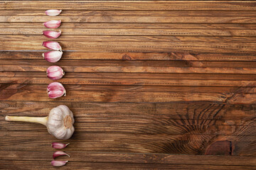 Spicy garlic is laid out in a straight line on a wooden table