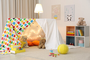 Play tent decorated with festive lights in modern child's room