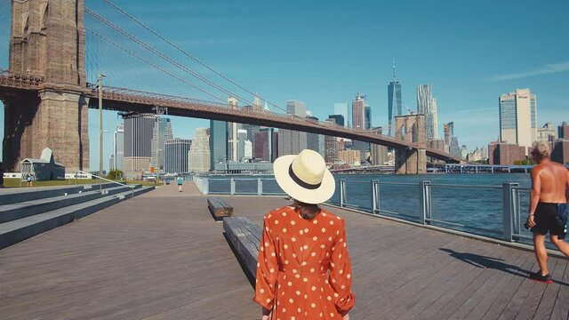 Young woman walking by the Brooklyn Bridge, New York