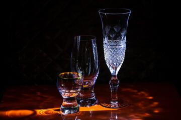 Glasses for wine and champagne and glasses for strong drinks on the bar.