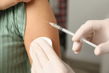 Doctor giving injection to patient in hospital, closeup. Vaccination day