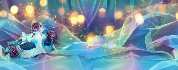 Photo of elegant and delicate Venetian mask over blue chiffon background © tomertu