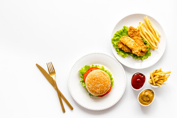 Burger and french fries with french fries and fried chicken, overhead view