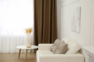 Sofa and window with brown curtains in simple room interior