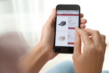 Woman using smartphone for online shopping indoors, closeup