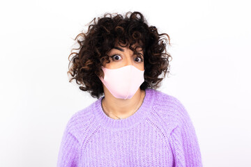 Portrait of dissatisfied young beautiful caucasian woman wearing medical mask smirks face, purses...