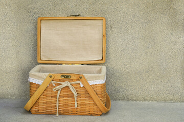 front view open weave wooden basket and white fabric on cement background, object, copy space