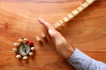 image of male hand stopping the domino effect. executive and risk control concept