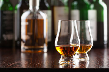 Bottle and glass of whisky spirit brandy on dark brown background