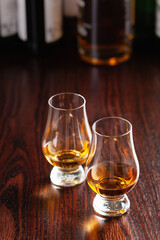 Bottle and glass of whisky spirit brandy on dark brown background