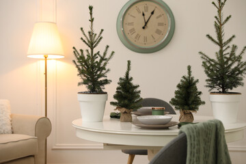 Small fir trees on dining table indoors. Christmas interior design