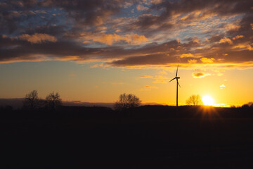 Fototapeta na wymiar Black Silhouette of windturbines energy generator on amazing sunset at a wind farm in langenberg, germany