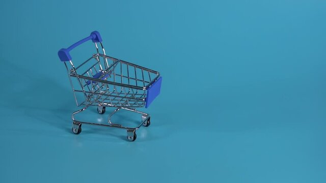 Funny Animation Toilet Paper Trolley Moving on a Blue Background. Stop Motion. Toilet Paper Shopping Concept