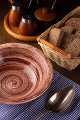 Empty ceramic plate, spice containers and bread in a basket