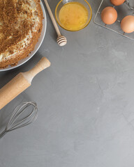 Ingredients for making honey cake on gray background