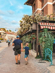 BULGARIA, GREAT TYRNOVO - 2019: Father and son walking through the old town holding hands.