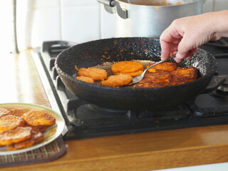 The process of cooking pumpkin pancakes at home in a pan on a stove.Diet healthy homemade food made from natural ingredients.
