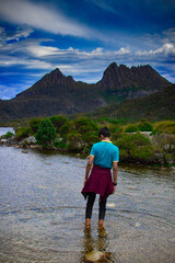 Boy standing in water in front of mountain