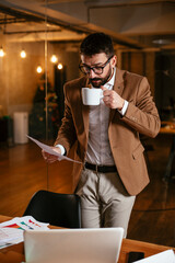 Young businessman drinking coffee in the office. Handsome man on coffee break.