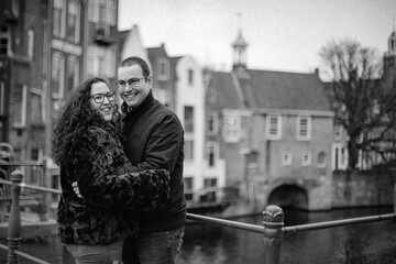 Two people in love walking around the old town in The Netherlands, hugging each other and kissing. A young woman and a man, a couple.