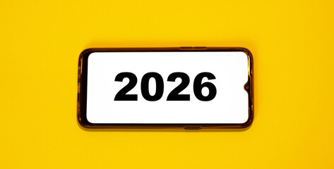 2026 on a smartphone. Smartphone concept with frameless shape on a light background.