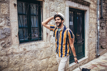 Handsome bearded tourist with backpack is making travel across city.