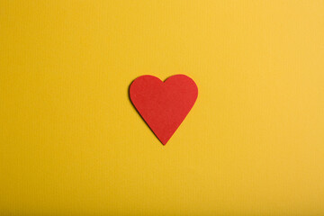 Paper heart on yellow background.