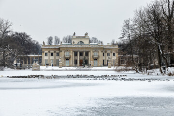 Fototapeta na wymiar historic palace on the water in Łazienki Królewskie park in Warsaw, Poland during snowy winter