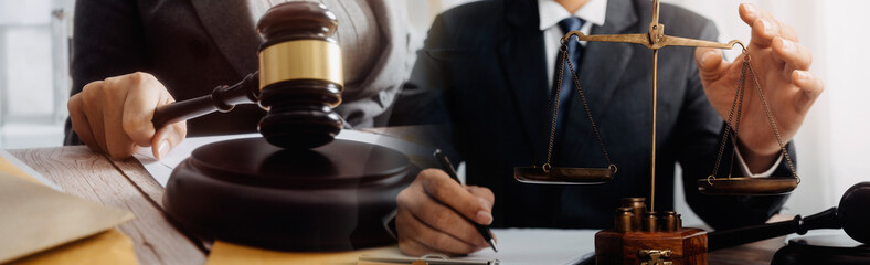 Business and lawyers discussing contract papers with brass scale on desk in office. Law, legal services, advice, justice and law concept	