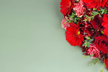Red bouquet flower on green background with copy space. Floral arrangement with roses and gerberas.