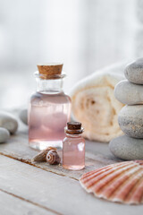 Natural organic spa products on wooden background. Essential rose oil, towel, stones. Atmosphere of relax, detention, zen. Aromatherapy. Body care, healthy lifestyle. Close up. Copy space for text.