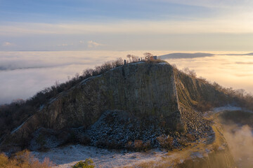 Monoszló, Hungary - Aerial view of volcanic basalt rock formation named Hegyestű with fog over...