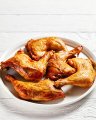 roast chicken legs on a white platter, top view