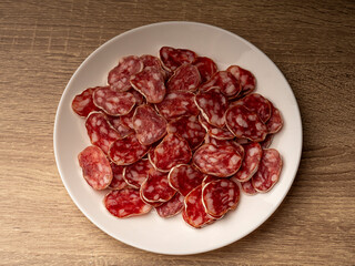 A lot of chopped salami that lies on a white plate, the plate lies