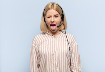 blonde woman with cheerful, carefree, rebellious attitude, joking and sticking tongue out, having...